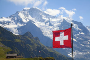 Государственный флаг Швейцарии на фоне Альп